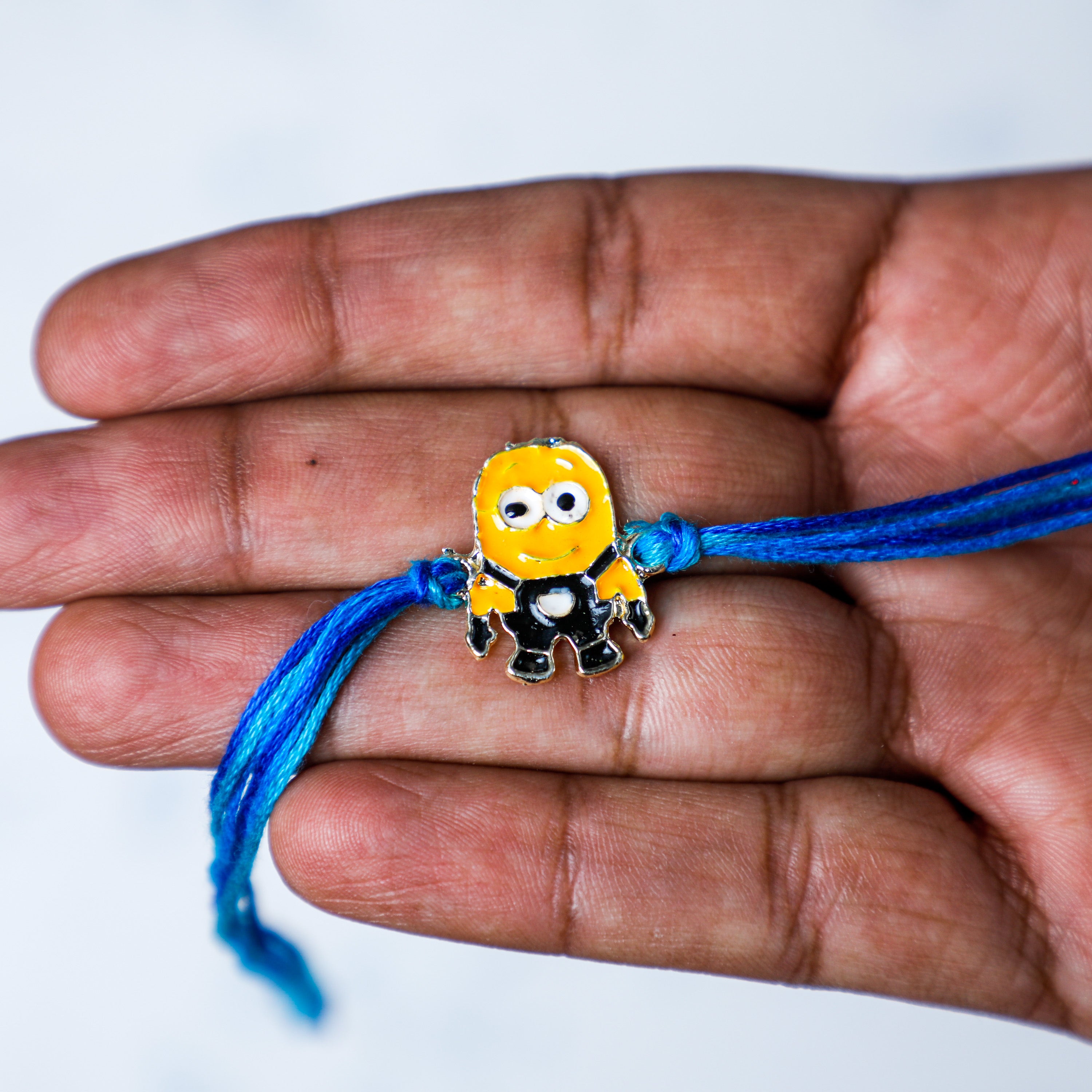 holding cute Minion cartoon Rakhi